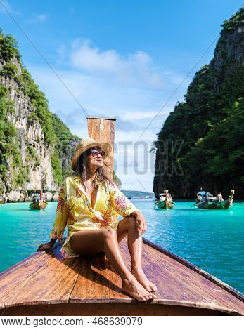 Asian Women In Front Of A Longtail Boat At Kho Phi Phi Thailand At Pileh Lagoon