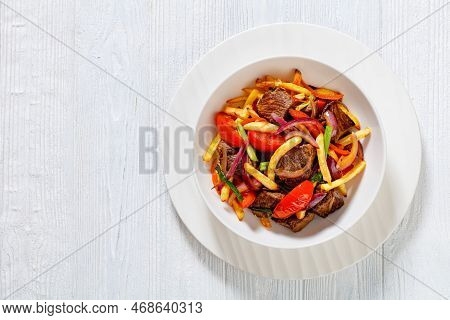 Lomo Saltado, Peruvian Dish Of Stir-fried Slices Of Beef Sirloin, Onions, Yellow Peruvian Chilis, An