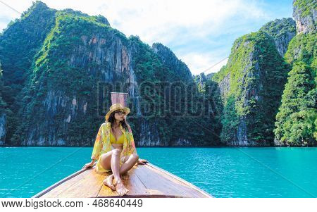 Asian Women In Front Of A Longtail Boat At Kho Phi Phi Thailand At Pileh Lagoon With Turqouse Water