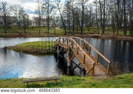 A Wooden Bridge From The Shore To A Small Island In The Lake In The Manor Park, Garsene, Latvia