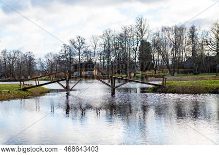 A Wooden Bridge From The Shore To A Small Island In The Lake In The Manor Park, Garsene, Latvia