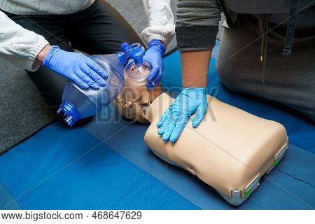 Man Using Cpr Technique On Dummy In First Aid Class. Oxygen Mask On Medical Doll. Stock Photo
