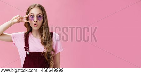 Portrait Of Stylish Energetic Girl With Scar On Hand Showing Peace Sign Over Eye Wearing Cool Sungla