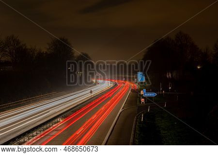 Long Exposure, White Front And Red Rear Lights As Car Light Strips At Night, German Text For Exit An
