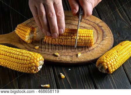 Cook's Hands With A Knife Cut Corn. Maize Is An Excellent Dietary Breakfast Or Lunch With Vegetables