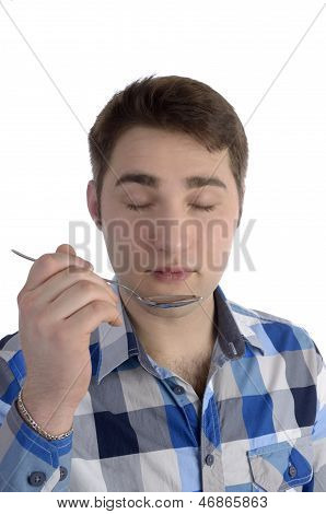 Young Man In Blue Shirt Is Smelling Spoon