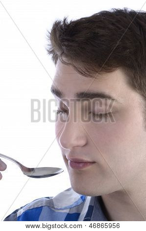 Young Man In Blue Shirt Is Smelling Spoon