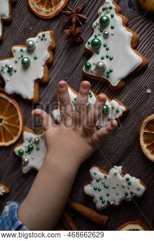 A Child's Hand Reaches For Ginger New Year's Beatiful Gingerbread Decorated In Silver And Green