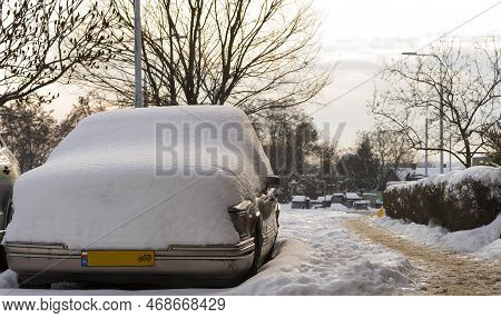 An Old Vintage American Car Under A Heavy Layer Of Snow . An American 