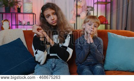Child Little Sister Kid Girls Praying Sincerely With Folded Arms, Looking Upward And Making Wish, As