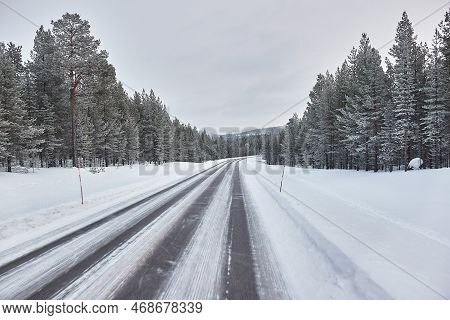 Driving On Snowy Winter Roads Of Finnish Lapland, Arctic Landsape, Icy Asphalt