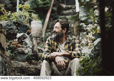 One Happy And Serene Adult Man Sitting Outdoor In The Green Nature Garden. Copy Space Image Of Alter