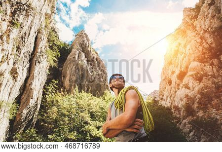 Smiling Climber Man In Protective Helmet And Sunglasses With Climbing Rope On The Shoulder In The Pa