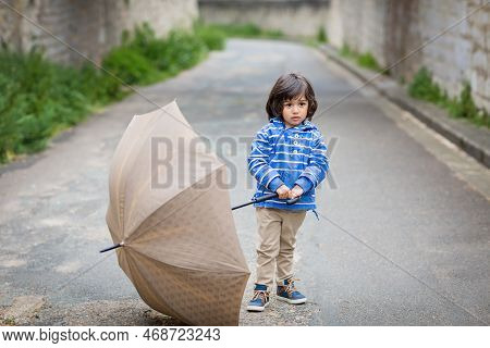 Little Handsome Baby Boy Playing With Umbrella Outdoor In Old Town. Boy Wearing Blue Jacket