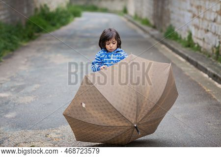 Little Handsome Baby Boy Playing With Umbrella Outdoor In Old Town. Boy Wearing Blue Jacket