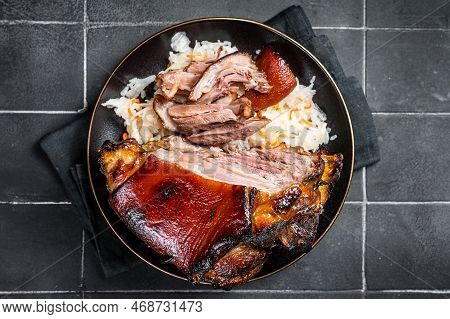 Roast Pork Ham Hock, Knuckle With Sauerkraut On A Plate. Black Background. Top View