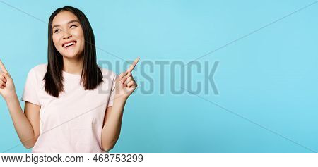Smiling Brunette Asian Woman, Pointing Sideways, Showing Both Ways And Laughing, Choosing In Store, 