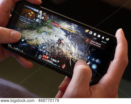Cork, Ireland, July 31, 2022. A Phone In The Hands Of A White Man. Playing Mobile Mmorpg Black Deser