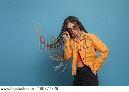 Beautiful Woman With Long African Braids And Sunglasses On Blue Background, Space For Text