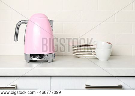 Modern Electric Kettle And Dishes On Counter In Kitchen