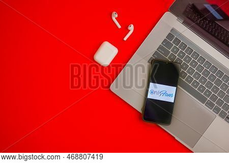 Tula, Russia - November 19, 2021: Logo Onlyfans Displayed On A Smartphone Near Modern Laptop On Red 