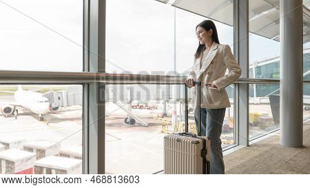 A young beautiful woman walking with suitcase , check in at International airport , vacation travel 