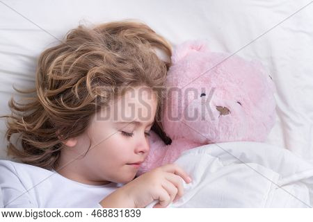 Cute Child Sleeping With A Toy Teddy Bear On Bed At Home. Bedtime, Kid Sleeps. Kid Asleep On Soft Pi