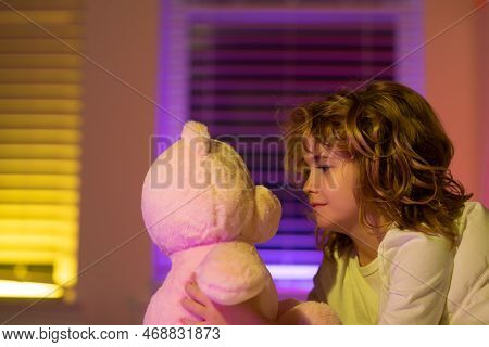 Child Play With Toy Teddy Bear. Kid In Bed With Toy Teddy Bear. Nap And Sleep Time. Bedding And Slee