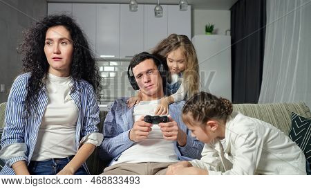 Insistent Daughters And Wife Try To Get Attention Of Father Playing Games With Controller. Man Enjoy