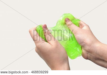 Hand Playing With Textured Slime On White Background. Teen Hand Holding Green Shining Slime With Bub