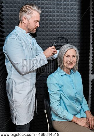 Audiometry, Pure Tone Audiogram Test. Audiologist Doing Hearing Exam To Mature Woman In Soundproof A
