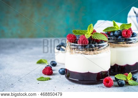 Parfait With Cream Or Yogurt, Jam And Fresh Berries In The Glass Jar. Close Up. Healthy Dessert Or S