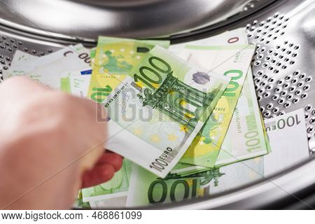 European One Hundred Euro Banknotes In Washing Machine And In Hand. Money Laundering Financial Conce