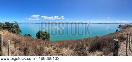 Panoramic View Of Picturesque Landscape With Dry Grass, Blue Sea And Mountains On Background In A Su