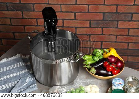 Sous Vide Cooker In Pot And Ingredients On Table. Thermal Immersion Circulator