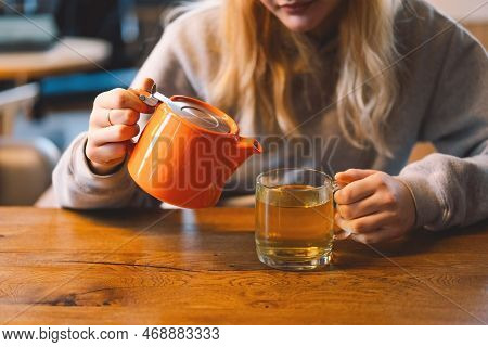Portrait Of A Joyful Teengirl Enjoying A Cup Of Tea At Cafe. Smiling Beautiful Girl Drinks Hot Tea I