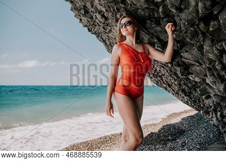Young Woman In Red Bikini On Beach. Blonde In Sunglasses On Pebb