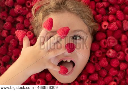 Fresh Raw Raspberry Near Kids Face. Raspberri Macro. Top View Of Collection Raspberries. Kid Holding