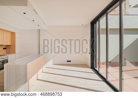 Large Bright Spacious Kitchen With Wooden Furniture And Closed Black Metal Sliding Glass Doors With 