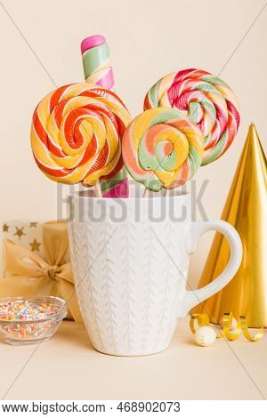 Colorful Candies In Cup On Table On Light Background Background. Large Swirled Lollipops. Creative C