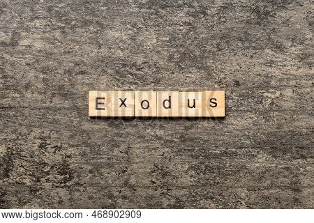 Exodus Word Written On Wood Block. Exodus Text On Table, Concept.