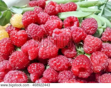 Fresh, Summer Berries - Green Peas In Pods And Red Raspberries. Green Peas Are In The Same Bowl With
