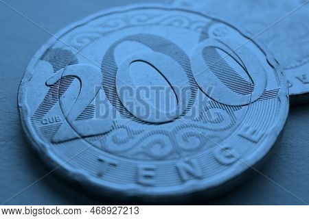 Translation: Tenge. Kazakh Coins. Blue Tinted Money Background. Coin 200 Tenge Close Up. Economy And