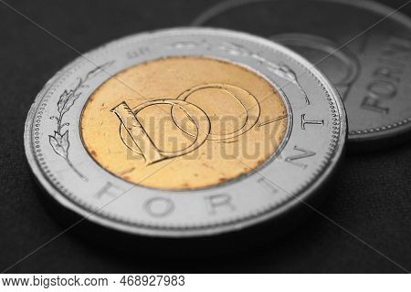 Hungarian Coin Of 100 Forints Lies On Dark Black Surface Close-up. Money Of Hungary. News About Econ