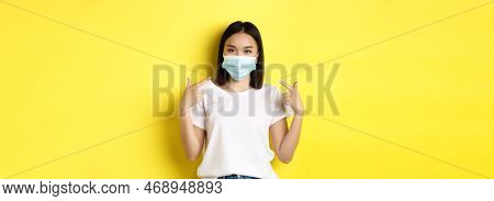Covid-19, Quarantine And Social Distancing Concept. Young Asian Woman In White T-shirt, Pointing At 