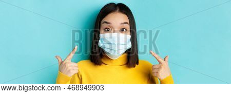 Covid-19, Social Distancing And Pandemic Concept. Close Up Of Surprised Asian Girl Pointing At Her M