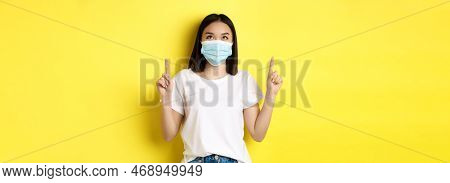 Covid-19, Pandemic And Social Distancing Concept. Young Asian Woman In White T-shirt And Medical Mas