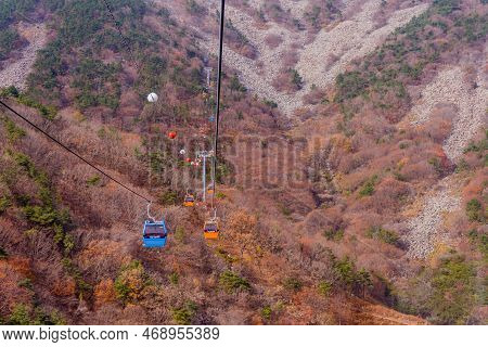 Hadong-gun, South Korea; November 24, 2022: Cable Cars Traversing Mountain Under Cloudy Sky
