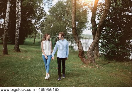 Couple In Love Standing Walking Along The Shore Of The Lake.