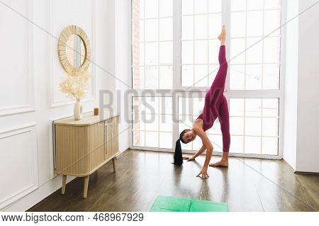 Young Athletic Woman Practicing Yoga, Performing Urdhva Prasarita Ekapadasana Exercise, Standing Wit